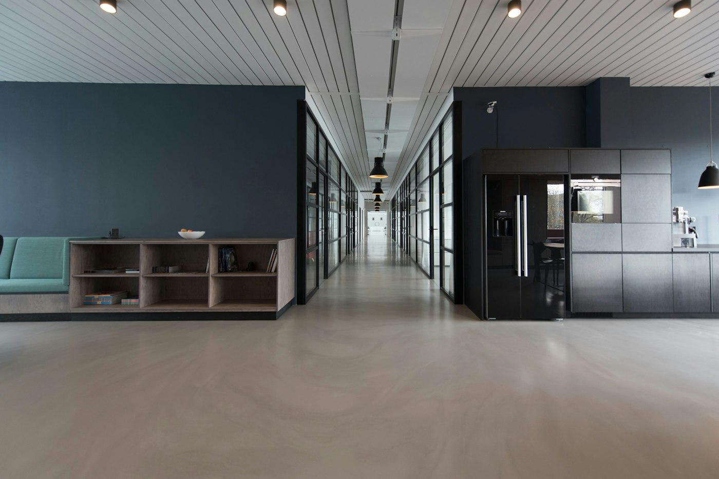 Open office interior with a lounge and a corridor of meeting rooms